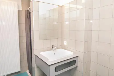 a white bathroom with a sink and a mirror at Hostel Bruegel in Brussels