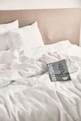 a book sitting on top of a white bed at TRUST Hotel in Beveren