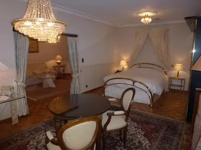 a bedroom with a bed and a table and chairs at Kasteel van Nieuwland in Aarschot