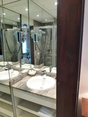 a bathroom with three sinks and a large mirror at Kasteel van Nieuwland in Aarschot