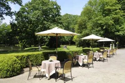 a row of tables and chairs with umbrellas at Kasteel van Nieuwland in Aarschot