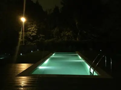 an empty swimming pool at night with a street light at Studio swimming pool BXL in Dilbeek