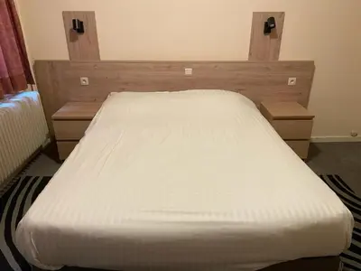 a bed in a bedroom with a white mattress at Hotel Bristol Internationaal in Mortsel