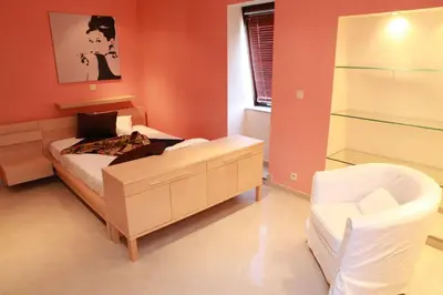 a small bedroom with a bed and a chair at Residence la Fraisiere in Brussels