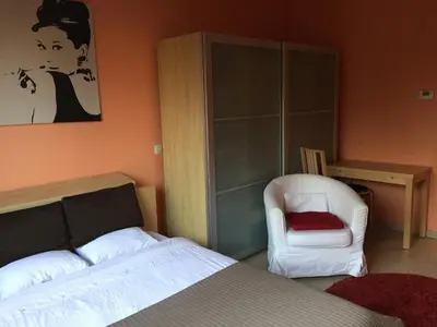 a bedroom with a bed and a chair at Residence la Fraisiere in Brussels
