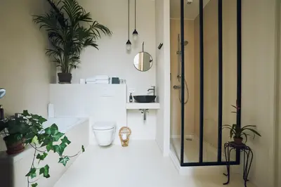 a bathroom with a shower and a toilet and plants at Latroupe Hotel Jardin Secret in Brussels