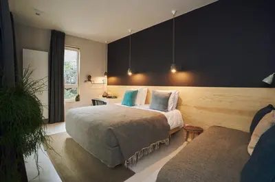 a bedroom with two beds and a couch at Latroupe Hotel Jardin Secret in Brussels