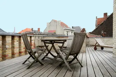 a wooden table and two chairs on a deck at Place 2 stay in Ghent