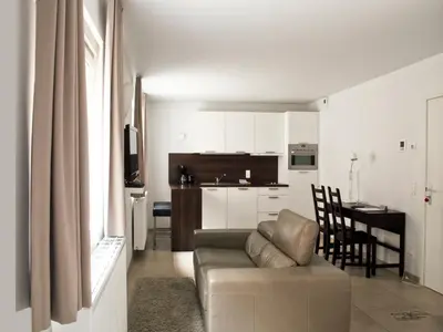 a living room with a couch and a kitchen at Place 2 stay in Ghent