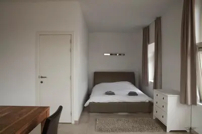 a small bedroom with a bed and a dresser at Place 2 stay in Ghent