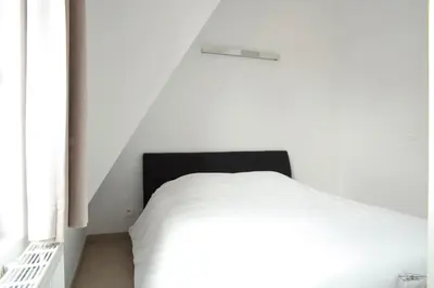 a bedroom with a white bed and a window at Place 2 stay in Ghent