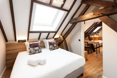 a bedroom with a white bed with two pillows at Hotel Onderbergen in Ghent