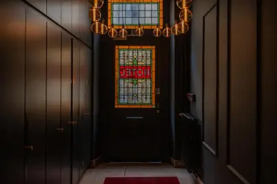 a hallway with a door and a stained glass window at Hotel Onderbergen in Ghent