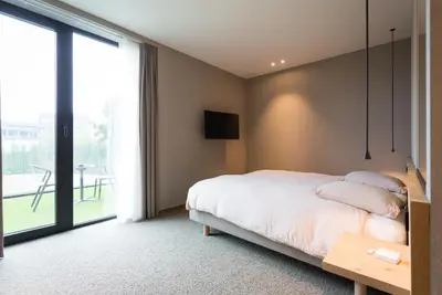 a bedroom with a bed and a large window at Hotel Den Berg in Londerzeel