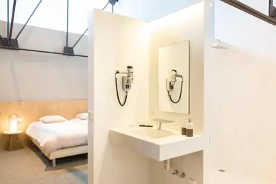 a bathroom with a sink and a bed at Hotel Den Berg in Londerzeel