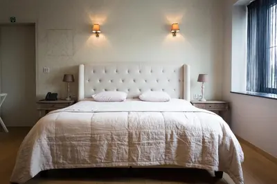 a bedroom with a large white bed with two pillows at Hotel Den Berg in Londerzeel
