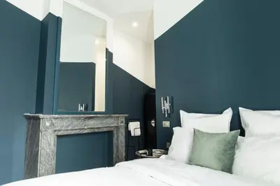 a blue bedroom with a bed and a fireplace at Wok Rooms in Brussels