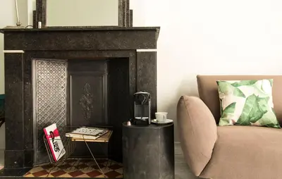 a living room with a chair and a fireplace at Wok Rooms in Brussels