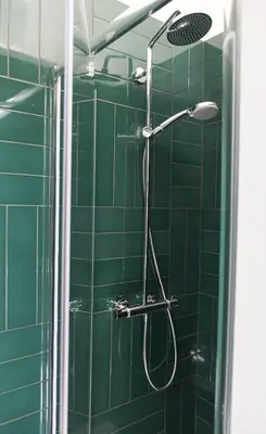 a green tiled shower with a shower head in a bathroom at Wok Rooms in Brussels