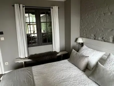 a bedroom with a white bed and a window at De Waterzooi Suites in Ghent