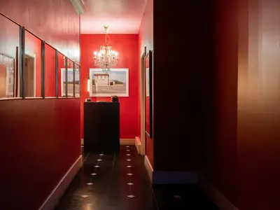 a hallway with red walls and a chandelier at Verne Dreams in Ghent