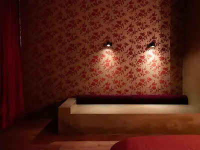 a room with a bed with red floral wallpaper at Verne Dreams in Ghent