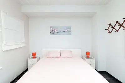 a bedroom with a white bed with two red candles at jutta in Mechelen
