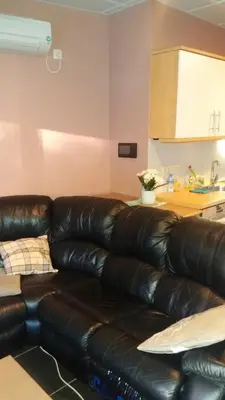 a leather couch in a living room with a kitchen at jutta in Mechelen
