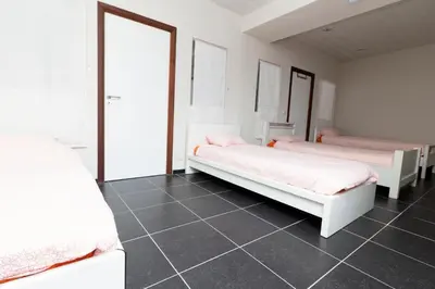 a bedroom with two beds and a tiled floor at jutta in Mechelen
