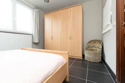 a bedroom with a bed and a chair at jutta in Mechelen