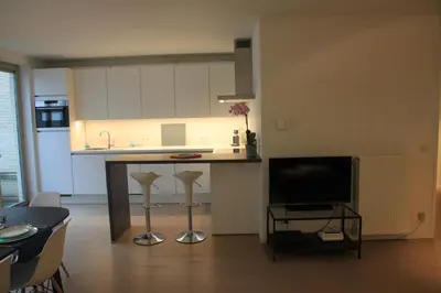 a kitchen with a counter and a tv in a room at NEW Design apartment in Brussels in Brussels