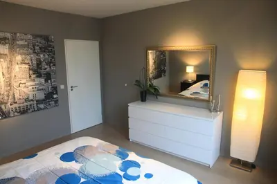 a bedroom with a bed and a mirror on a dresser at NEW Design apartment in Brussels in Brussels
