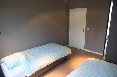a small bedroom with two beds and a door at NEW Design apartment in Brussels in Brussels