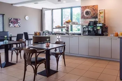 a restaurant with tables and chairs and a kitchen at Hobbit Hotel Mechelen in Mechelen
