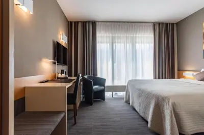 a hotel room with a bed and a desk at Hobbit Hotel Mechelen in Mechelen