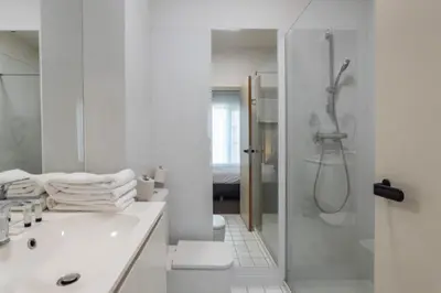 a white bathroom with a shower and a sink at Hobbit Hotel Mechelen in Mechelen