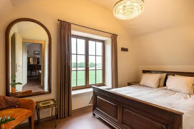 a bedroom with a bed and a large window at Chez Maintje in Bassevelde
