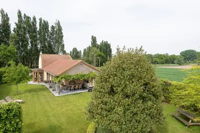 a house with a gazebo in a yard at Chez Maintje in Bassevelde
