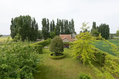 an aerial view of a garden with trees and a house at Chez Maintje in Bassevelde
