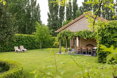 a house with a yard with chairs and a table at Chez Maintje in Bassevelde