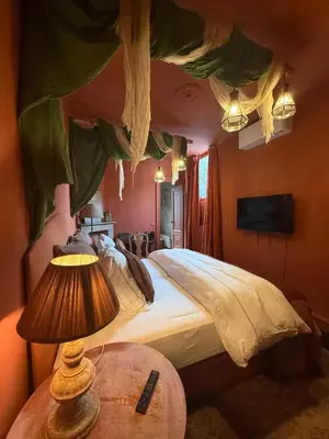 a bedroom with a bed and a table with a lamp at Guesthouse Nights by Morpheus in Antwerp