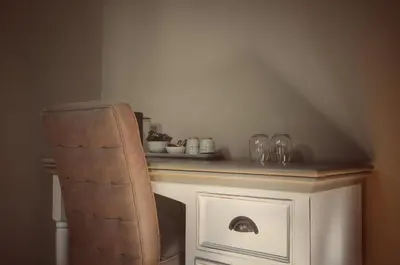 a chair sitting next to a table with glasses on it at B&B Stillant in Gierle