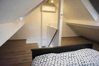 an attic bedroom with a bed and a staircase at Apartments Berlaymont OHY in Brussels