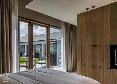 a bedroom with a bed and a large window at De Koolputten in Waasmunster