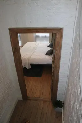 a small bedroom with a bed and a mirror at Mañana Mañana in Antwerp