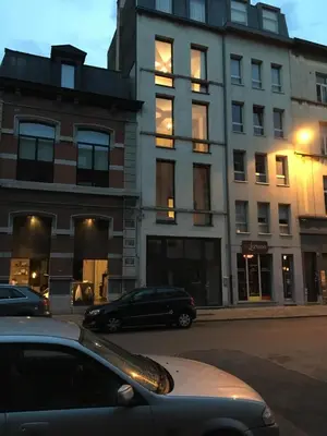 a car parked in front of a tall building at Mañana Mañana in Antwerp