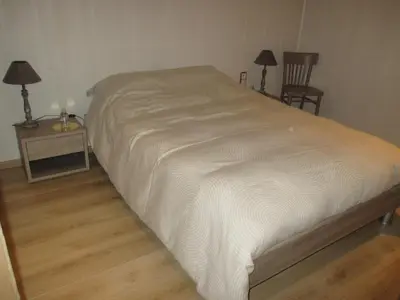 a bed in a bedroom with two tables and two lamps at Vakantieverblijf-Beestenboel in Retie