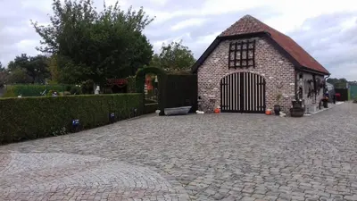 a small brick building with a gate in a driveway at Vakantieverblijf-Beestenboel in Retie