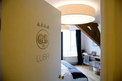 a room with a bed and a lamp on a wall at Les Chambres de Martin in Brussels