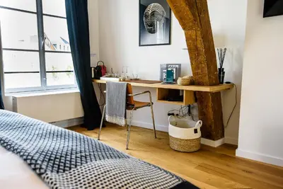 a bedroom with a desk and a bed and a window at Les Chambres de Martin in Brussels